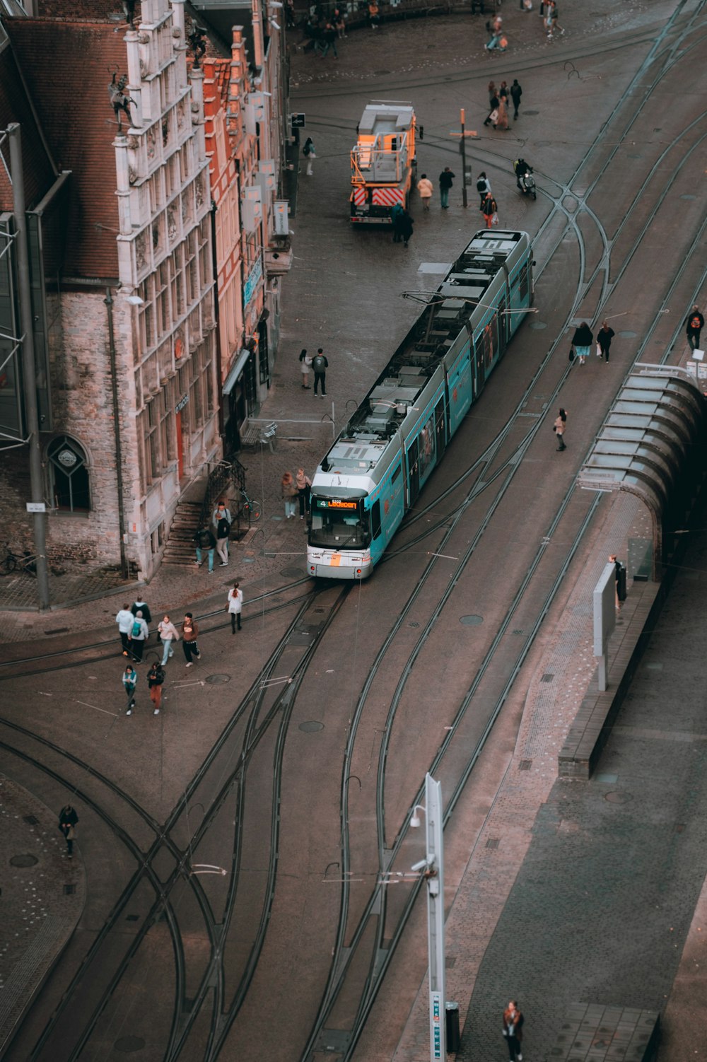 a train traveling down tracks next to a tall building