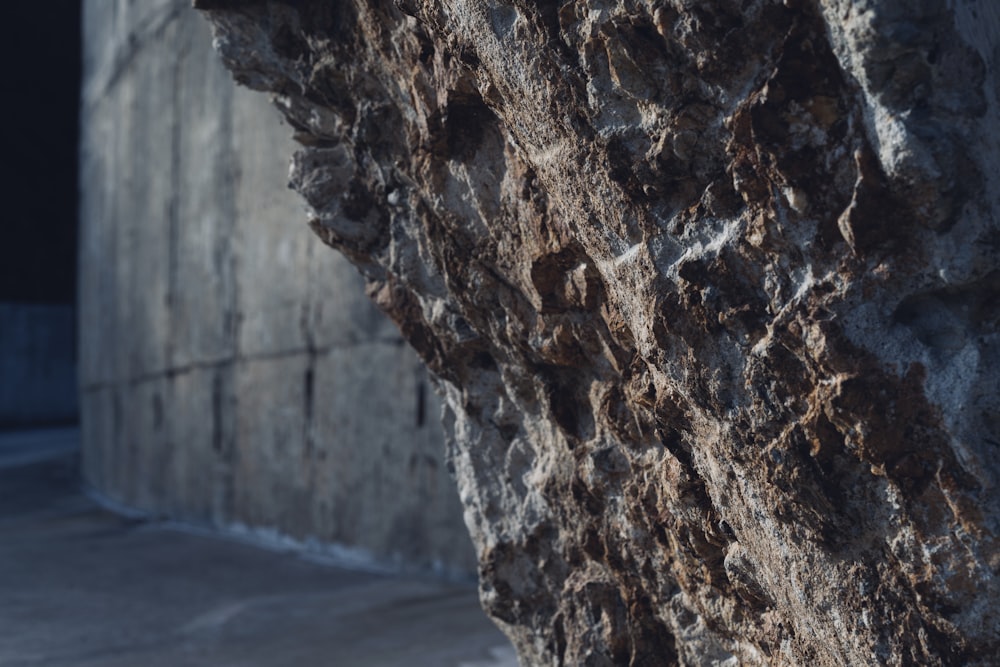 a close up of a rock face with a building in the background