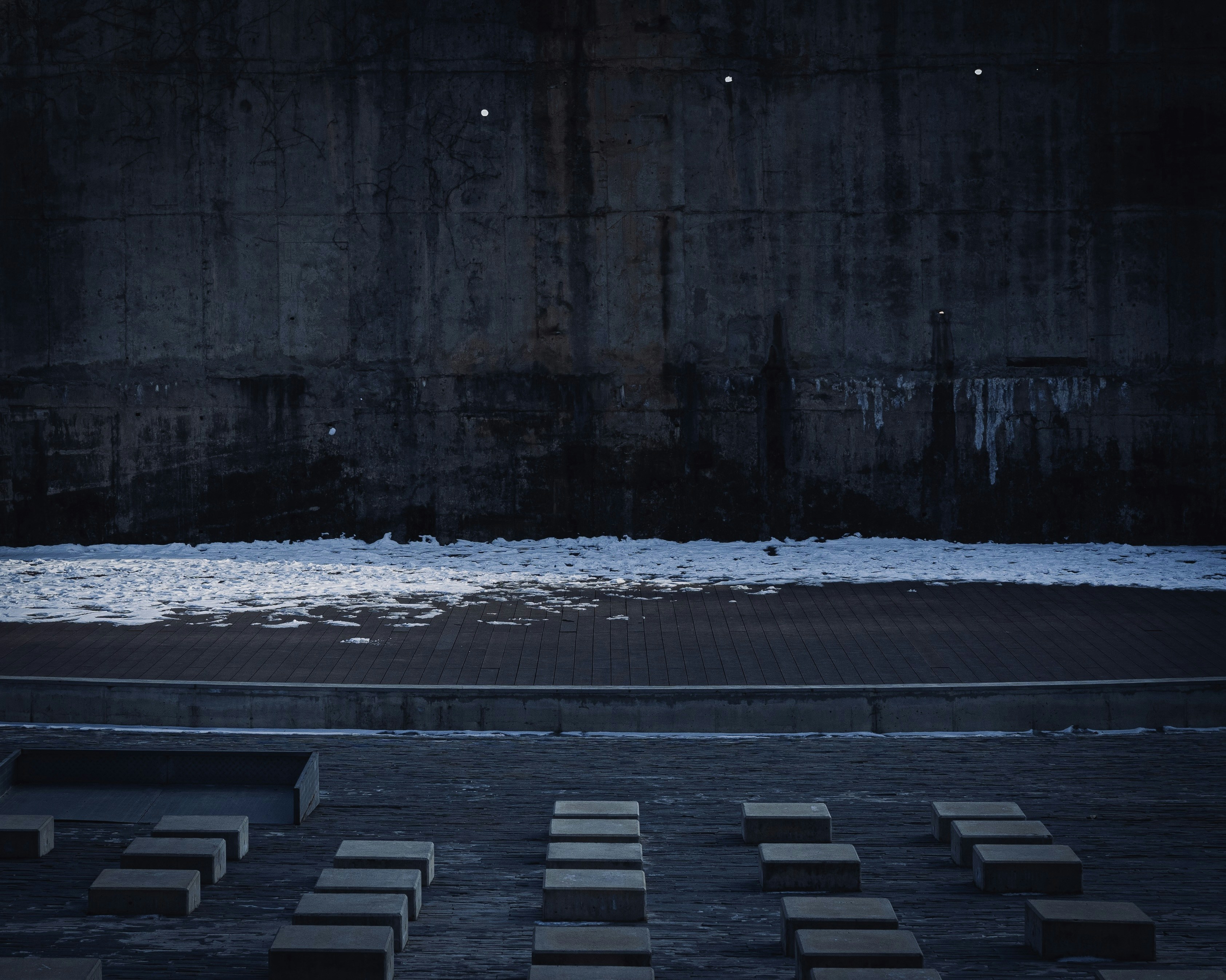 eine Bank vor einer Betonwand