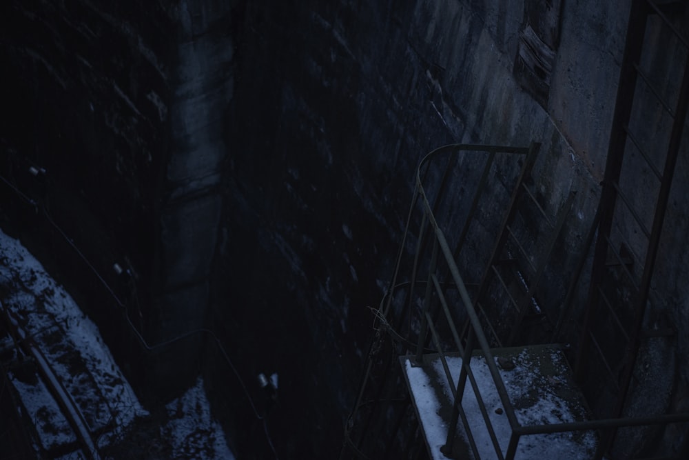 a stair case in a dark room with snow on the ground