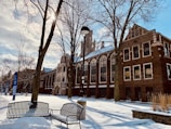 a bench sitting in the snow in front of a building