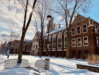a bench sitting in the snow in front of a building