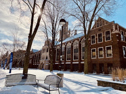 a bench sitting in the snow in front of a building