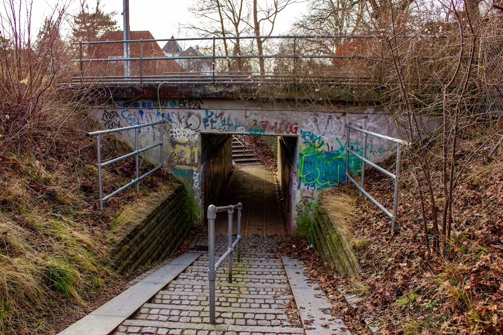 a concrete tunnel with graffiti on the walls