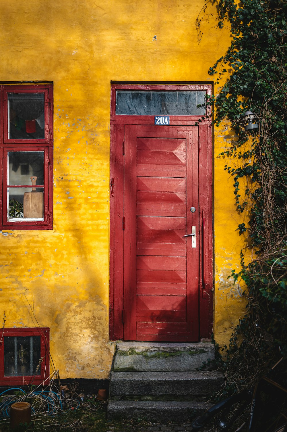a yellow building with a red door and window