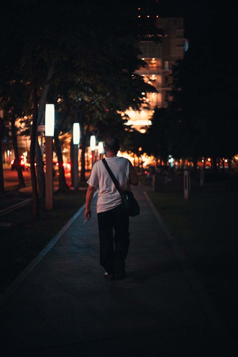 a man walking down a sidewalk at night