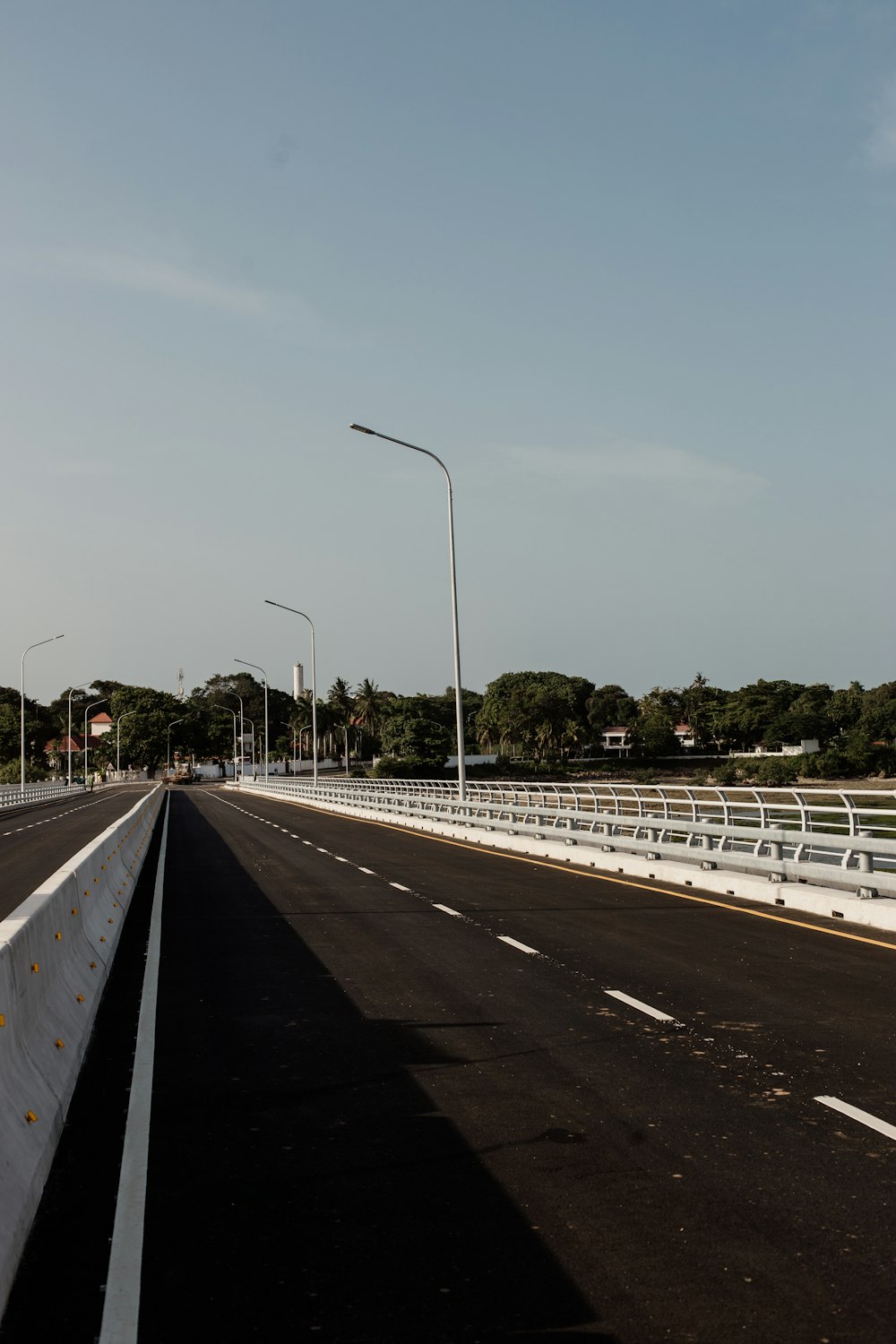 a road with a white fence and a street light