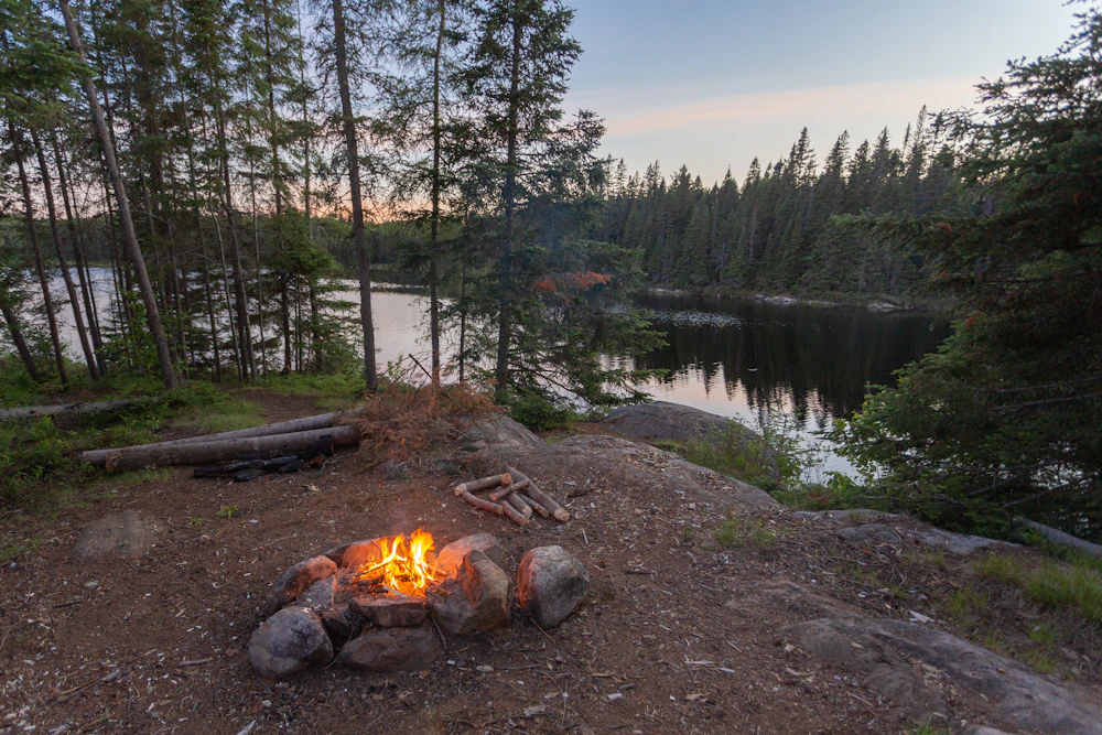 A campfire beside a lake in Algonquin Park
