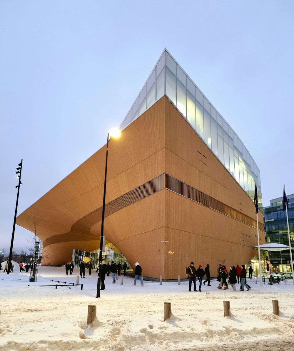 a large building with people walking around in the snow