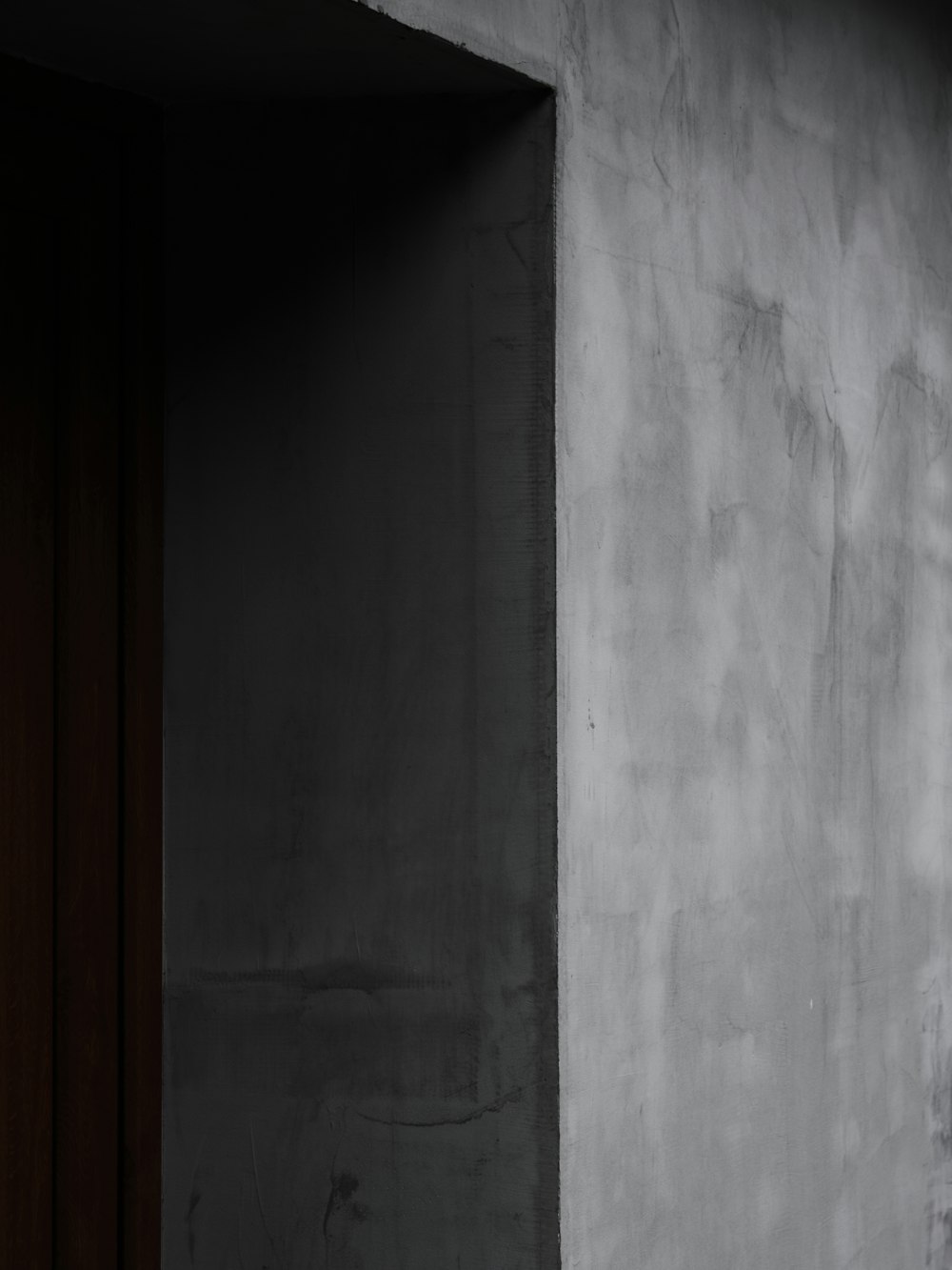 a black and white photo of a door and a wall