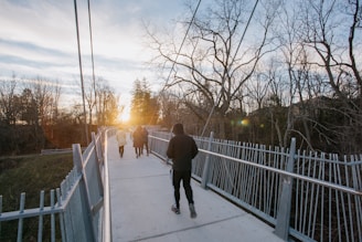 a group of people walking across a bridge