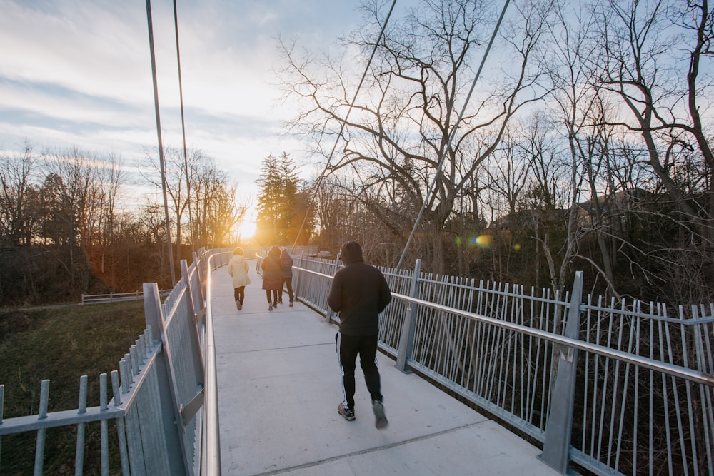 a group of people walking across a bridge