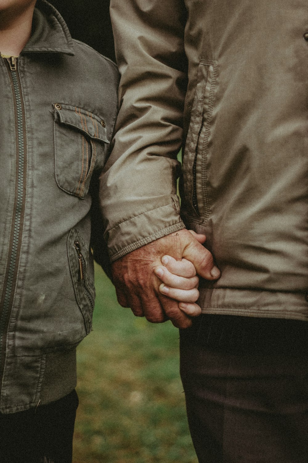 a close up of two people holding hands