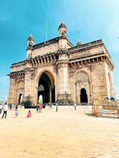 A group gathered around a guide sharing stories near a historic stone monument.