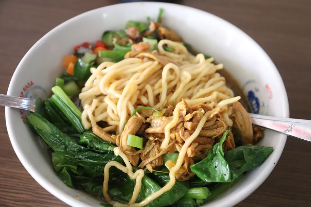 a close up of a bowl of food with noodles