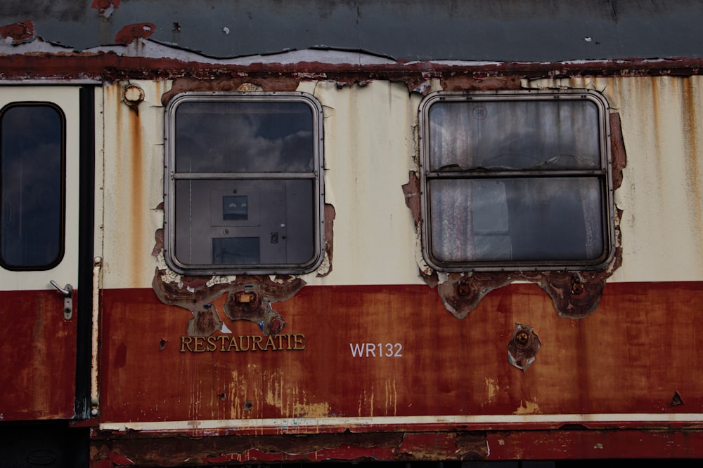 an old rusted train car with three windows