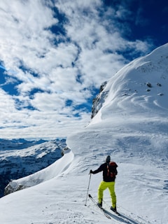 a man riding skis down the side of a snow covered slope
