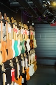 Rows of guitars displayed neatly on stands, showcasing various shapes and colors.