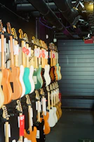 Rows of colorful guitars and violins displayed neatly on wooden racks inside the store.