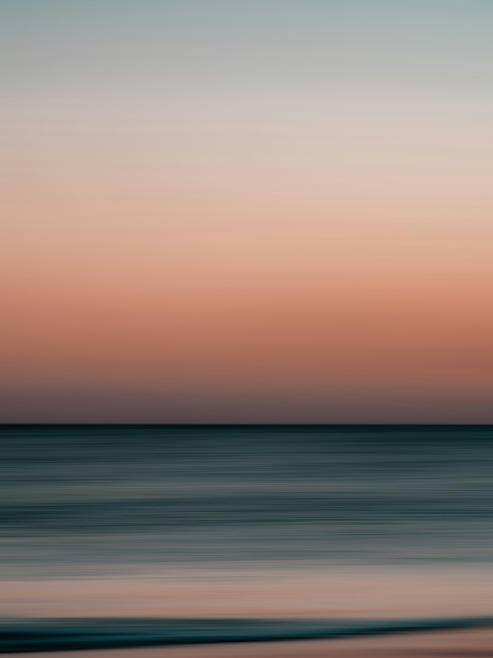 Ein verschwommenes Foto des Ozeans bei Sonnenuntergang