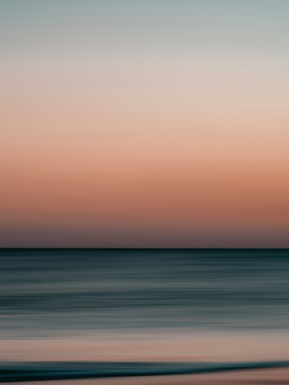 a blurry photo of the ocean at sunset