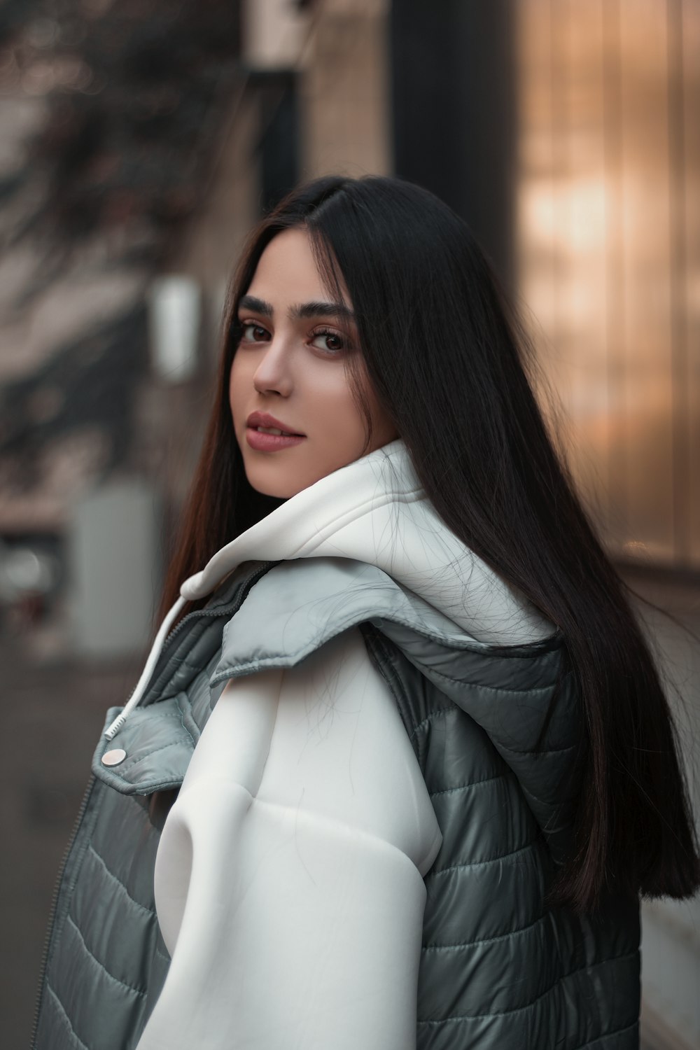 a woman with long black hair wearing a jacket