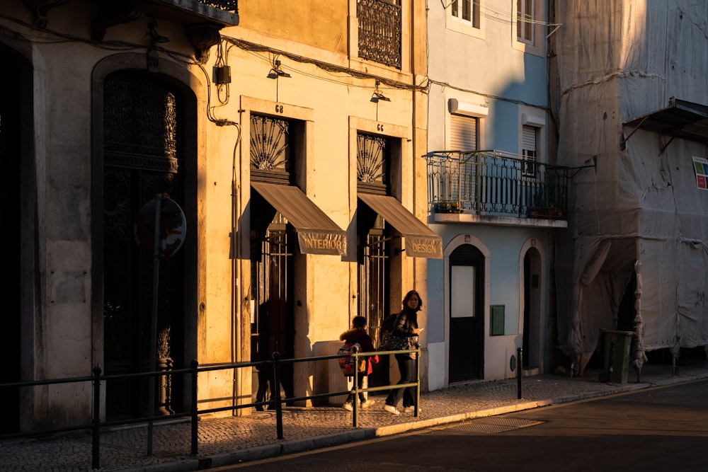 a couple of people sitting on a bench in front of a building