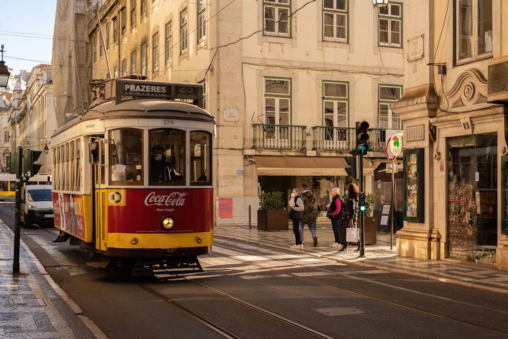 a red and yellow trolley on a city street