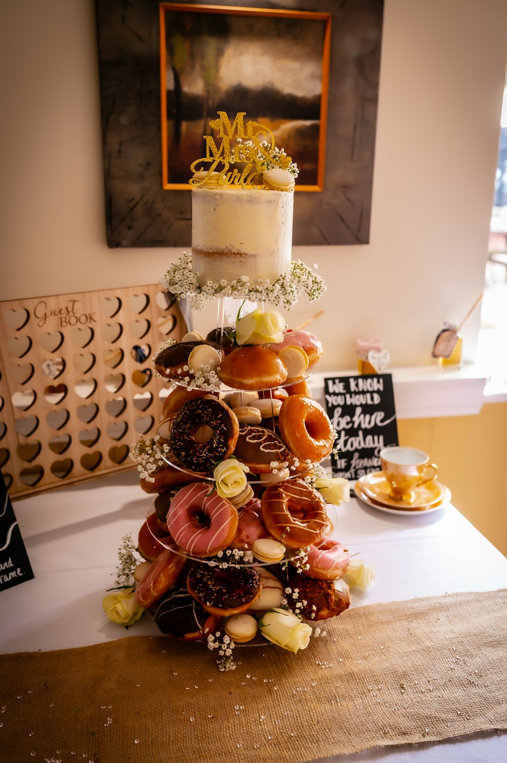a table topped with a cake covered in donuts