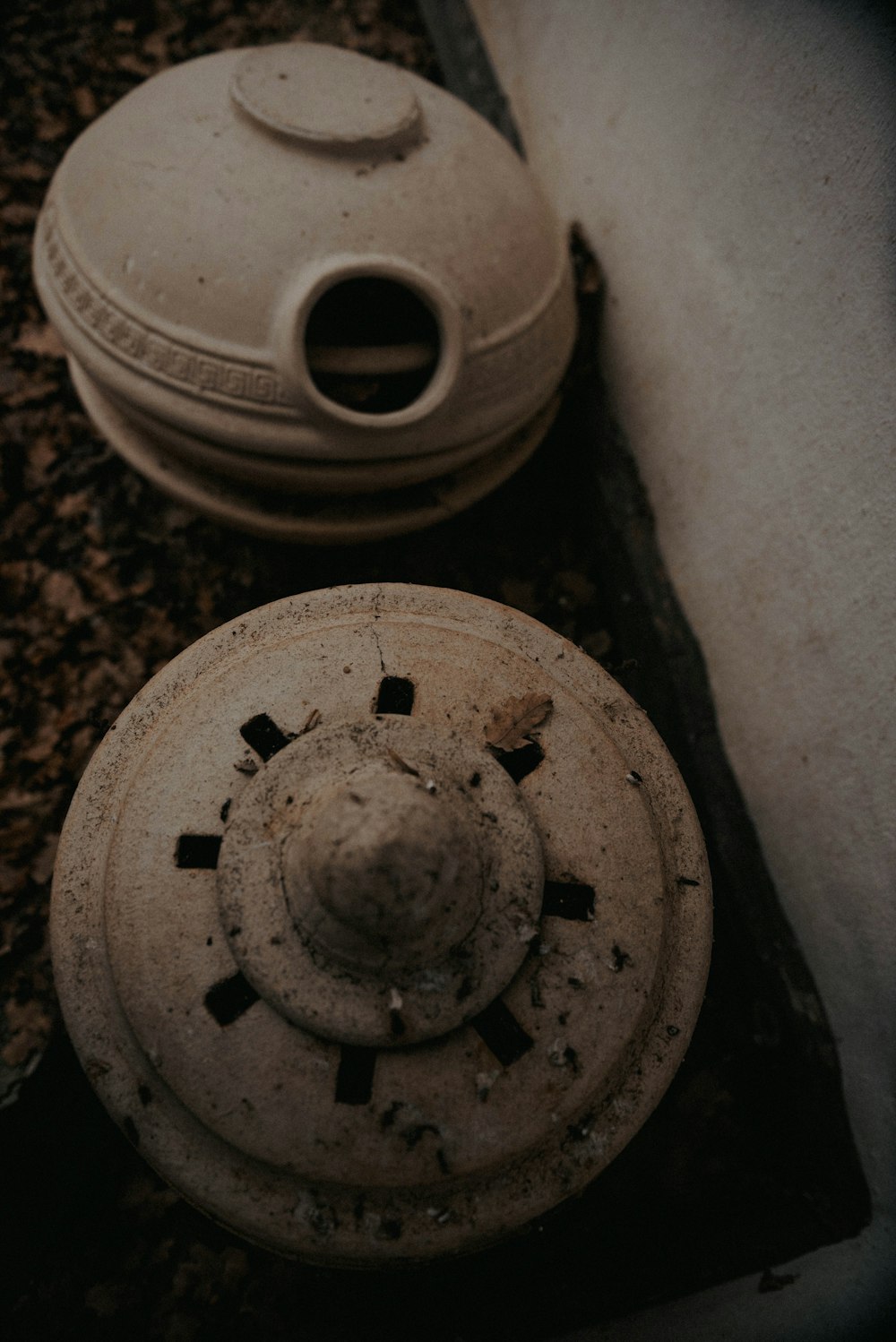 two old pots sitting on the ground next to each other