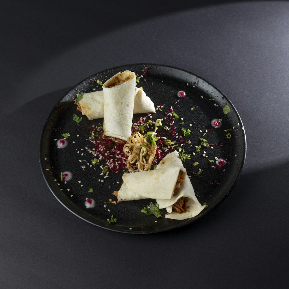 a black plate topped with food on top of a table