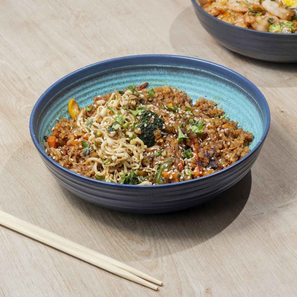 a bowl of noodles and vegetables on a table