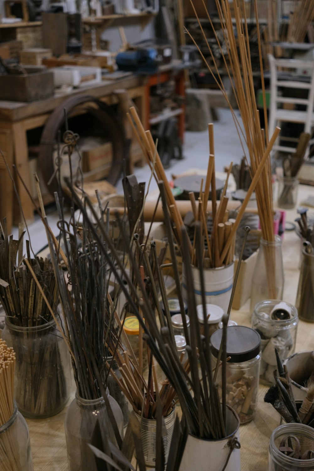 a group of vases filled with lots of sticks