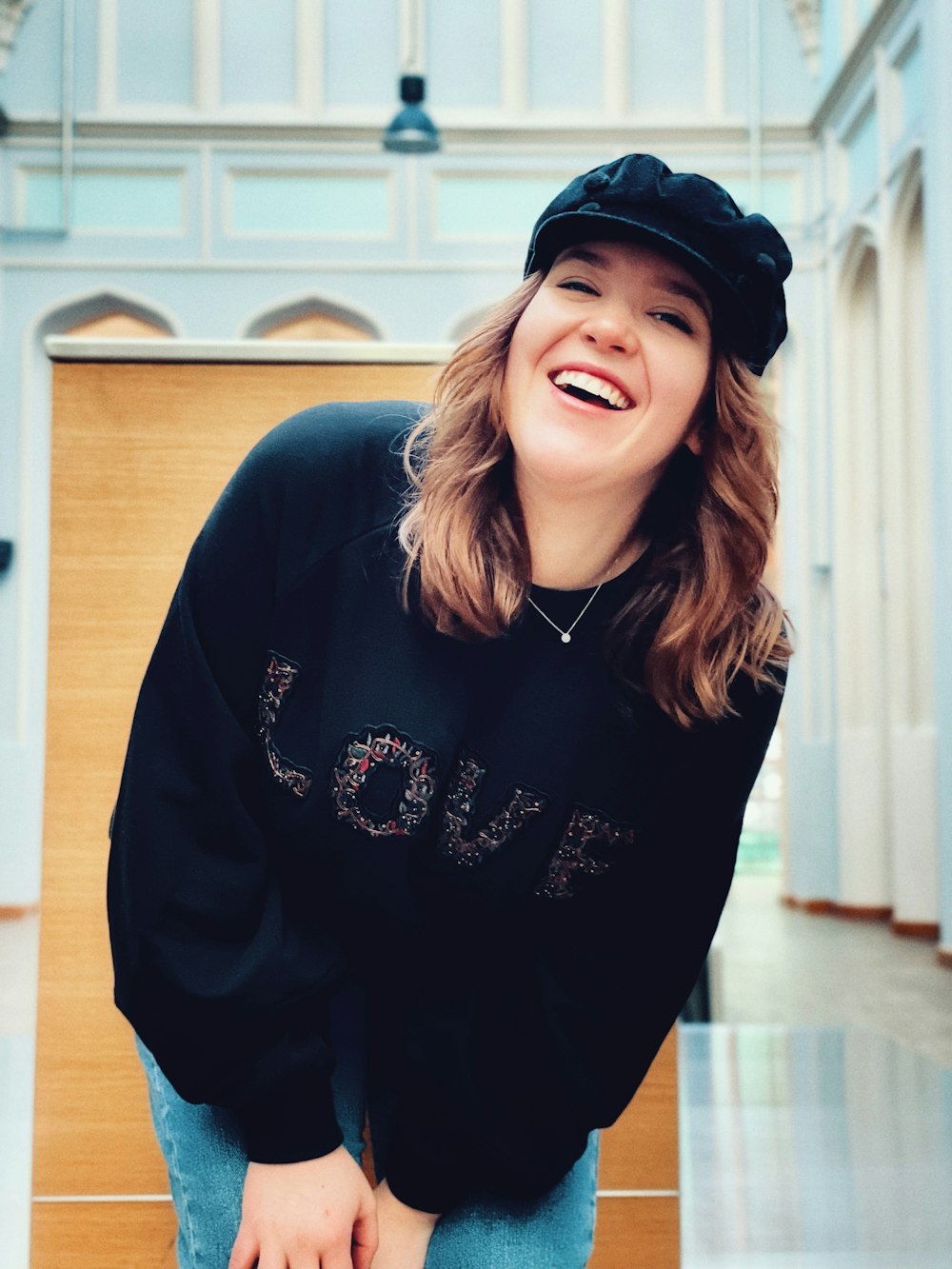 a woman in a black sweater and hat smiling