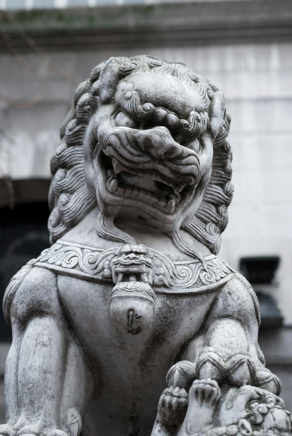 a stone lion statue in front of a building