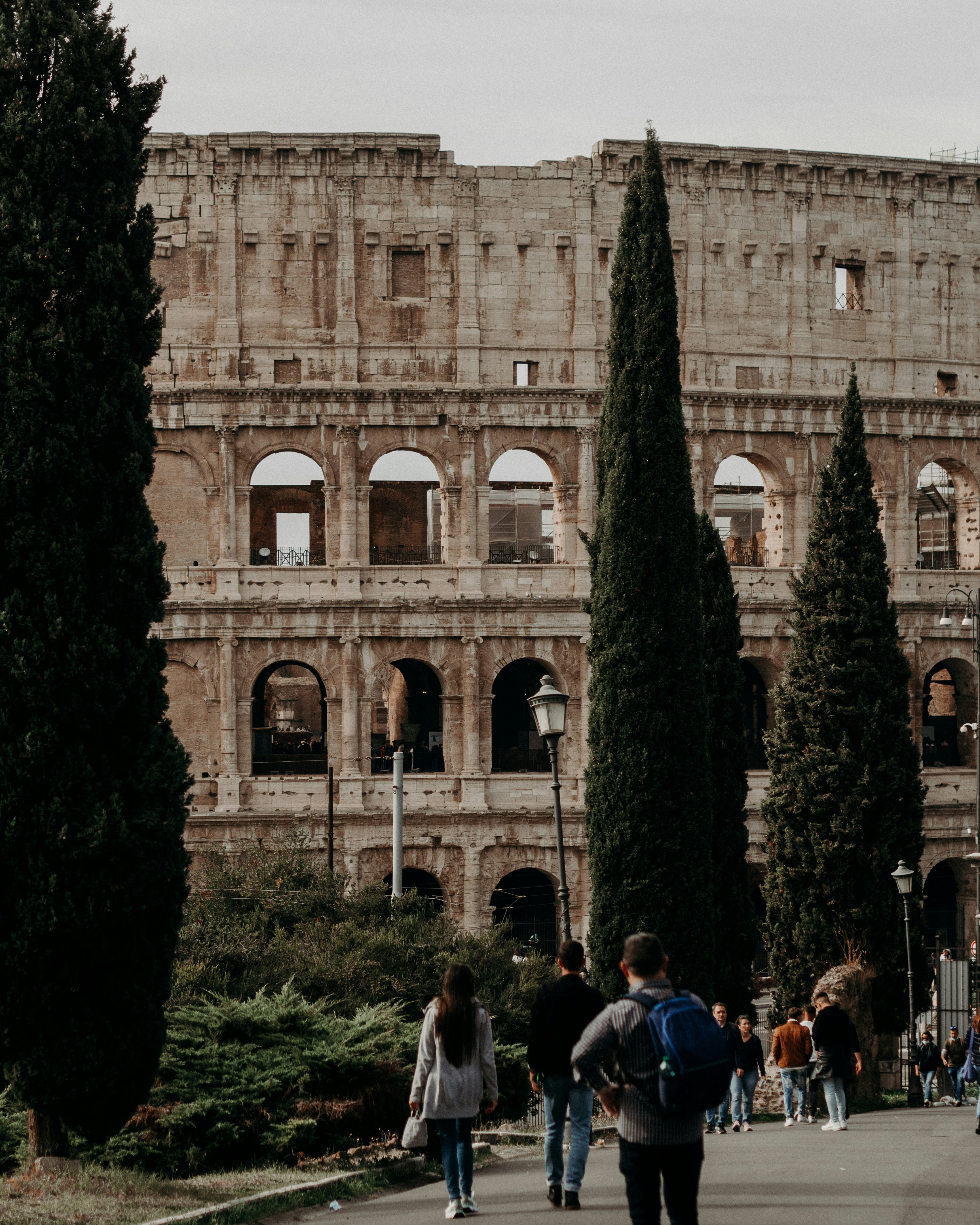 a group of people walking down a street next to a tall building