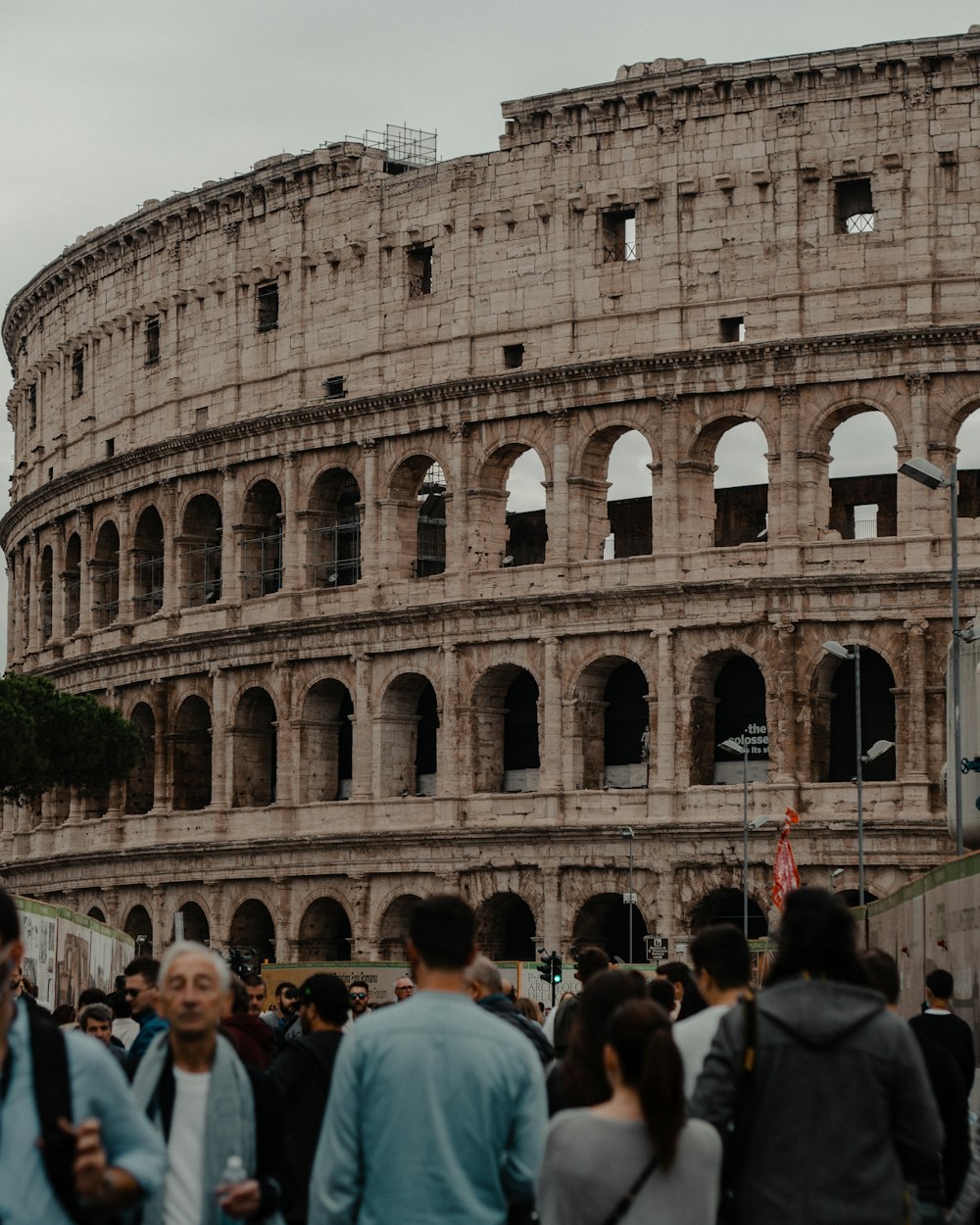 a crowd of people walking around an old building