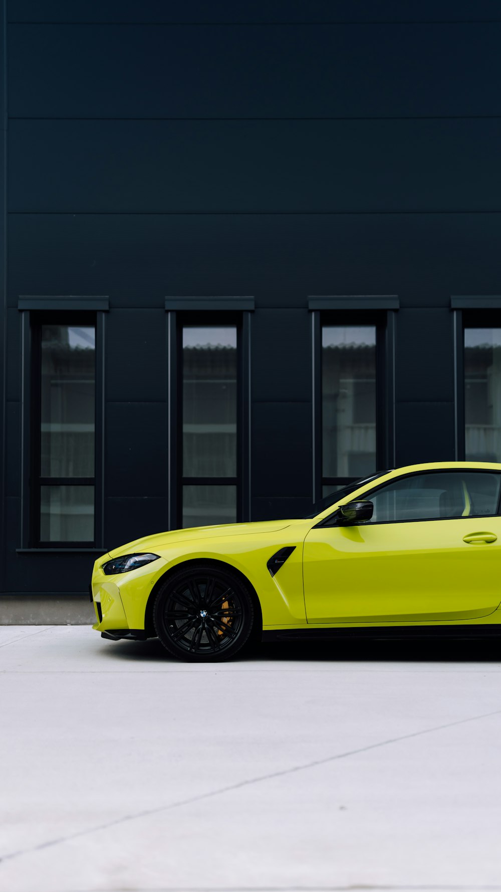 a yellow sports car parked in front of a building