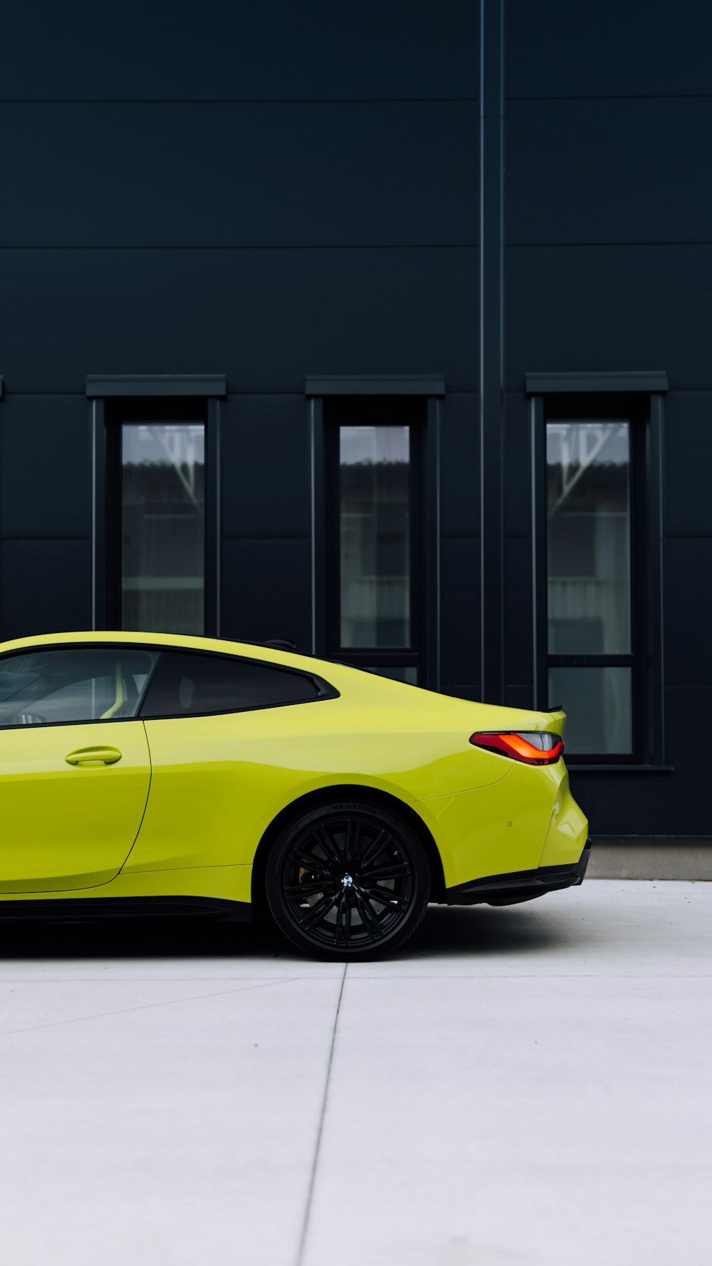 a yellow sports car parked in front of a building