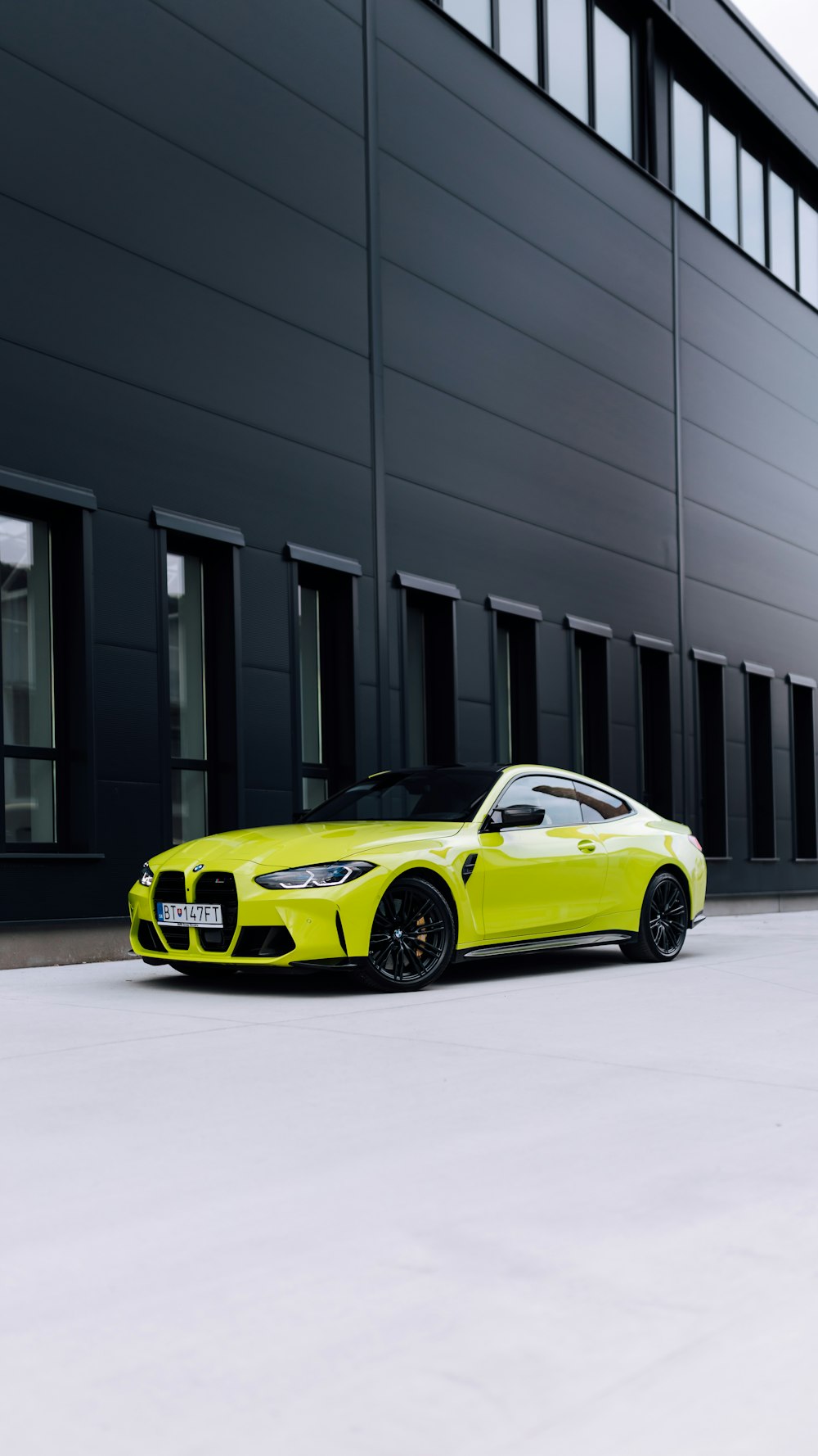 a yellow sports car parked in front of a building