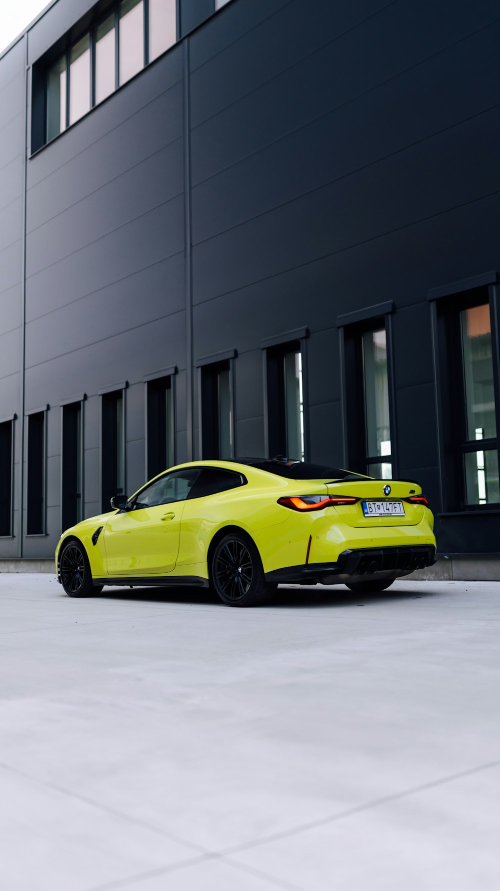 a yellow sports car parked in front of a building