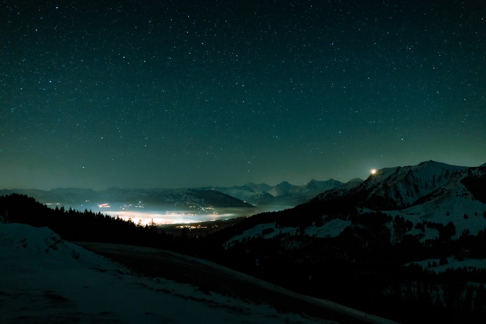a night view of a mountain range with stars in the sky