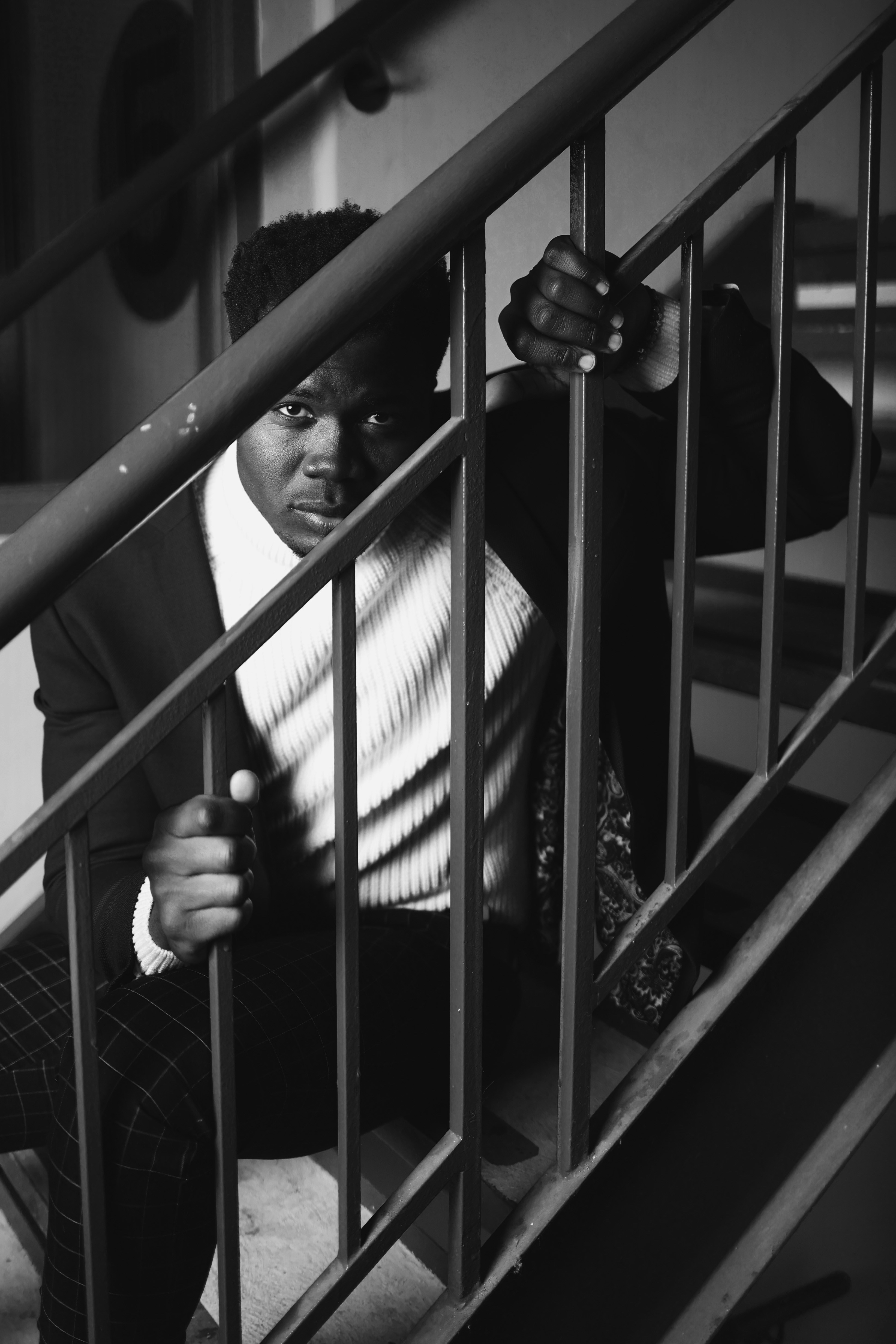 a man in a suit leaning on a railing
