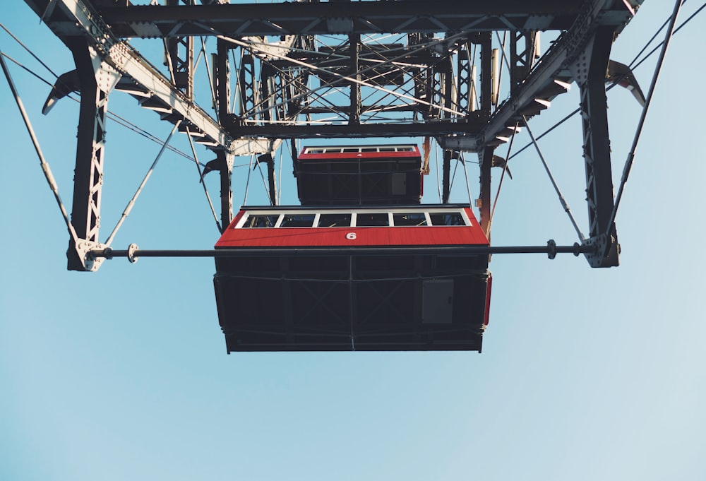 a red and black tram going up a hill