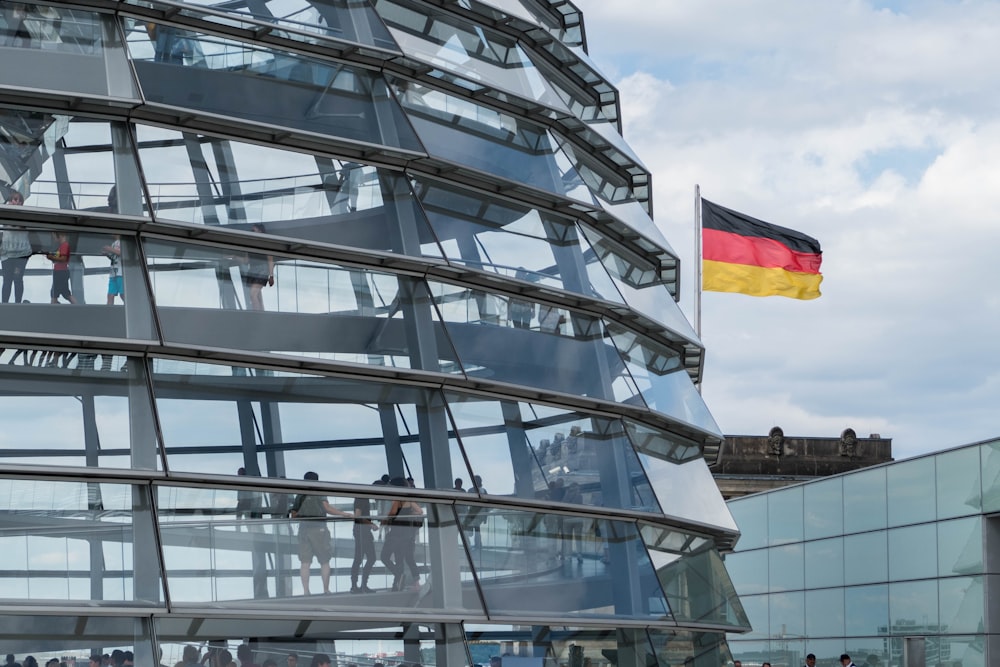a glass building with a german flag on top of it