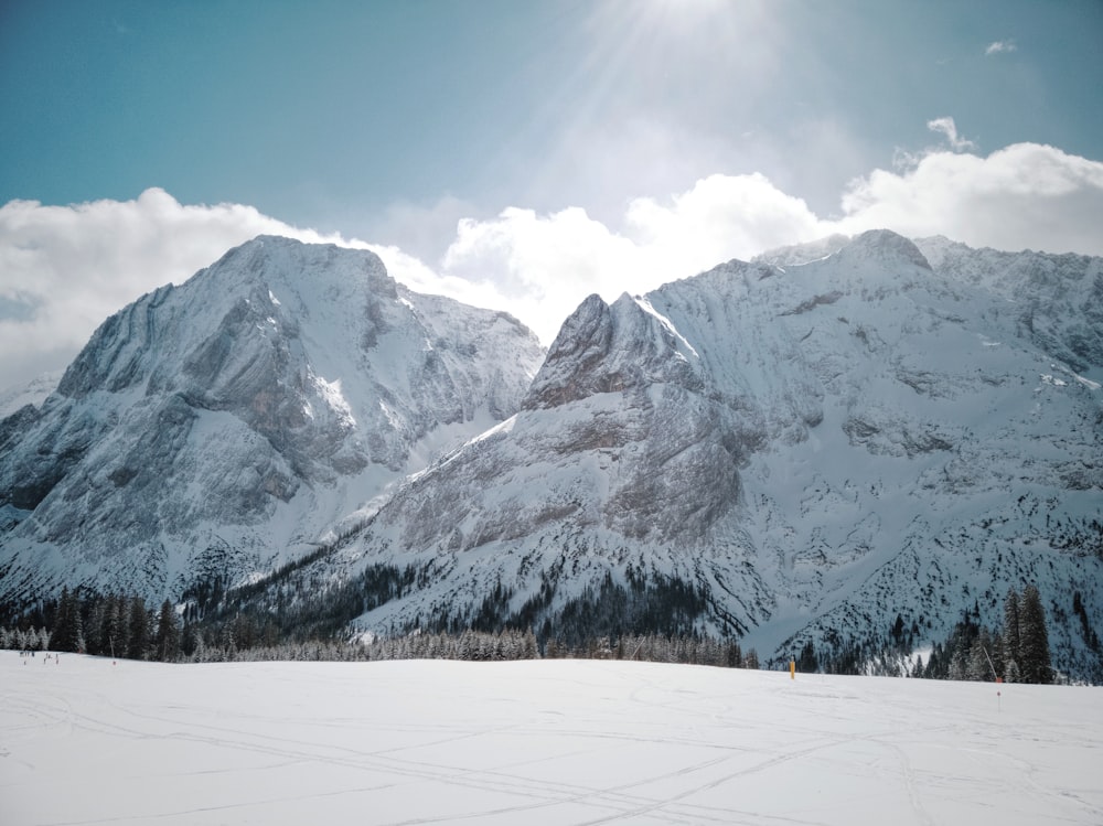 a snow covered mountain range with a ski slope in the foreground