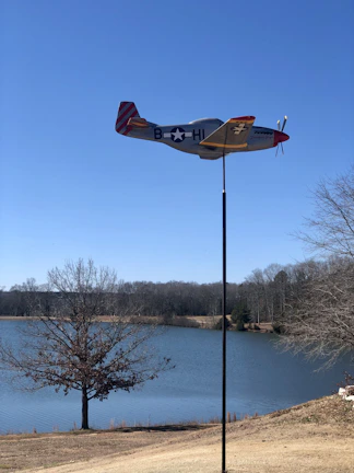 A model RC aircraft in mid-flight against a clear blue sky