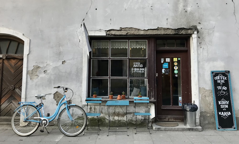un vélo bleu garé devant un immeuble