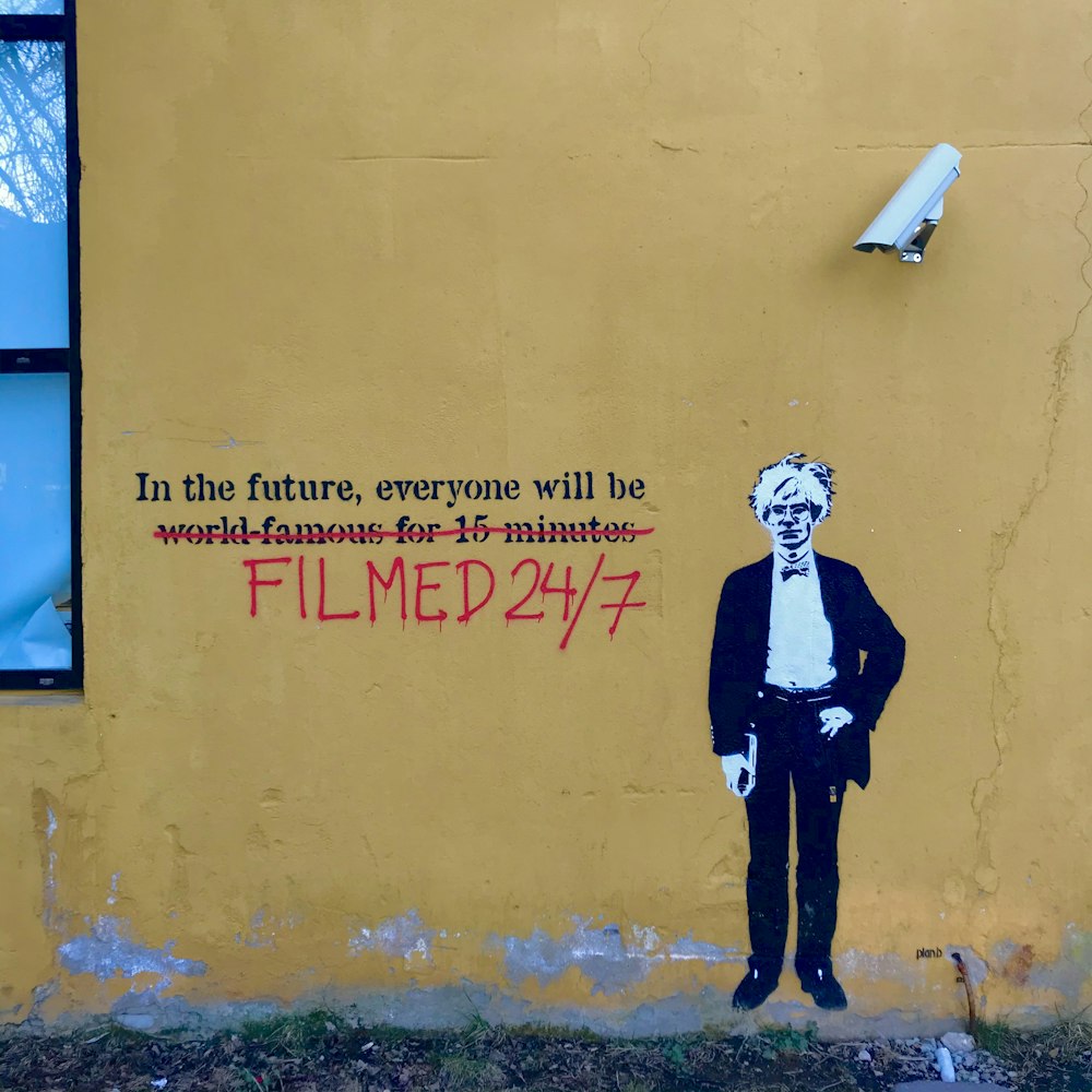 a painting of a man in a suit and tie on a yellow wall