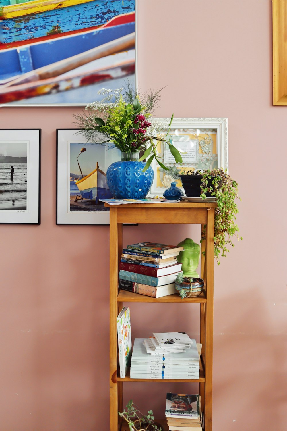a shelf with books and plants on top of it